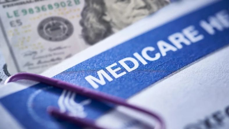 Medicare document with US dollar bill and paper clip